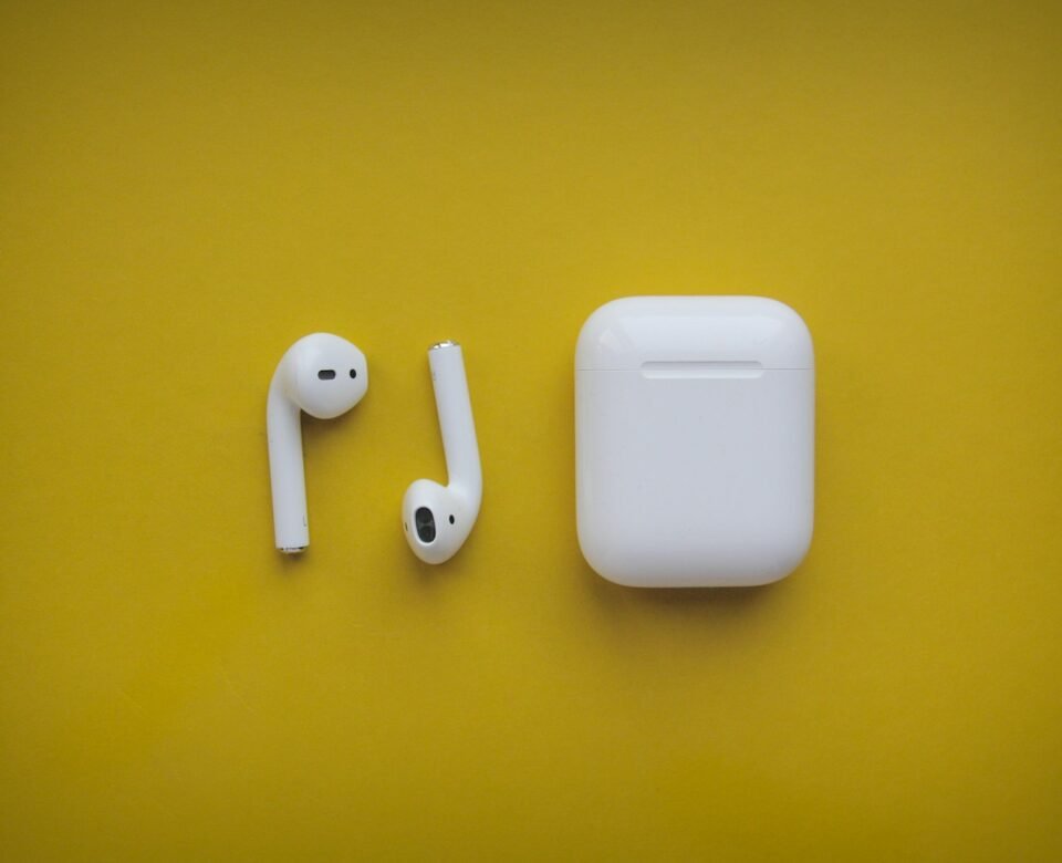 white apple airpods on yellow surface