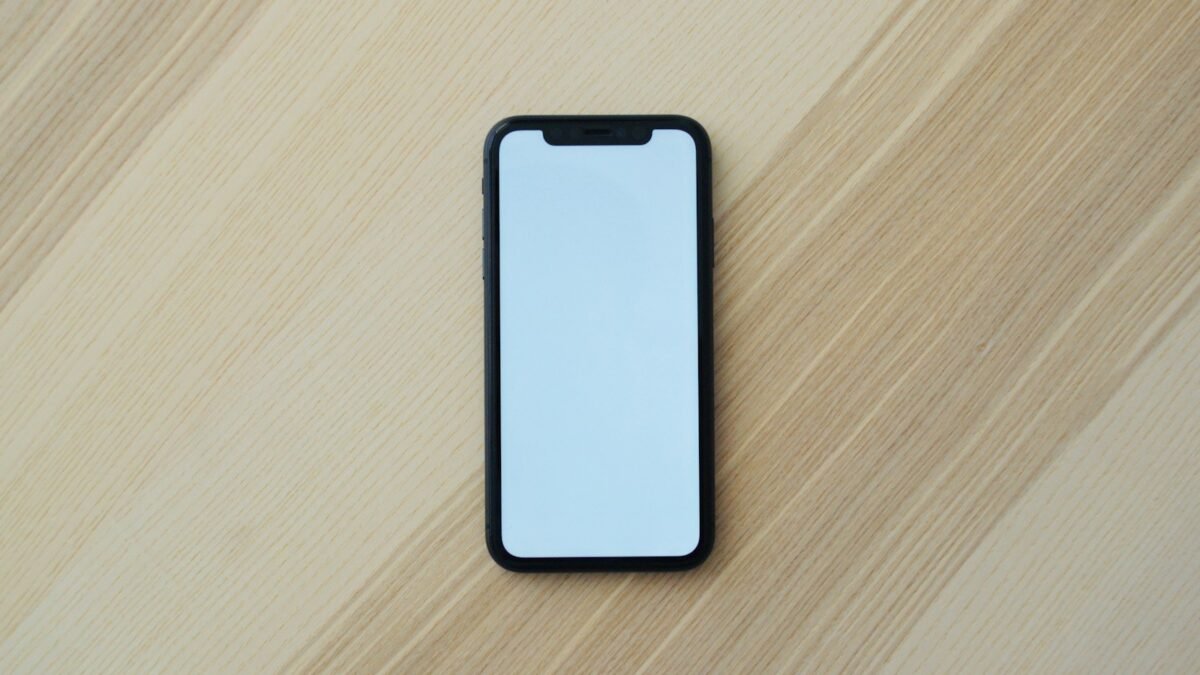 white smartphone on brown wooden table